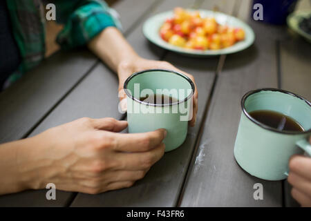 Two people seated at a table, drinking coffee, viewed from above. Stock Photo