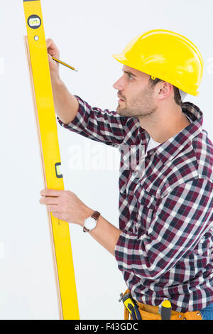 Technician marking while using spirit level Stock Photo