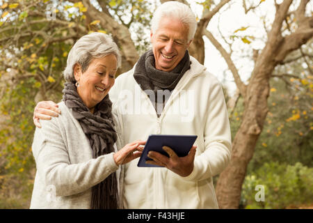 Senior couple in the park using tablet Stock Photo
