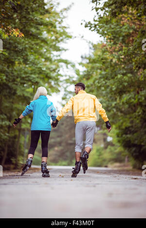 Happy couple roller blading together Stock Photo