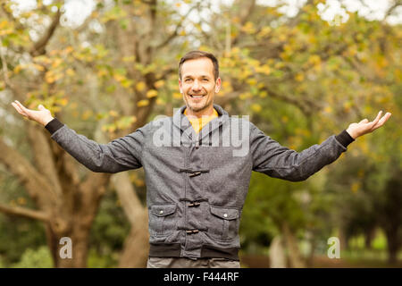 Young handsome man with raised arms Stock Photo