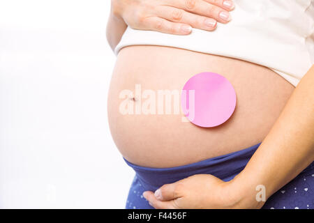 Pregnant woman with sticker on bump Stock Photo