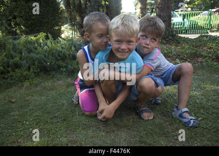Young boys posing for a portrait. Two brothers with their younger cousin on the left. Stock Photo