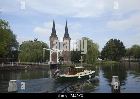 Across the canal are the twin spires at the Old East Gate to the city of Delft, Netherlands Stock Photo