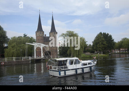 Across the canal are the twin spires at the Old East Gate to to the city of Delft, Netherlands Stock Photo