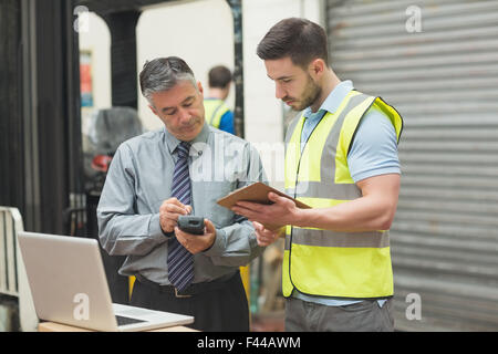 Workers scanning package in warehouse Stock Photo