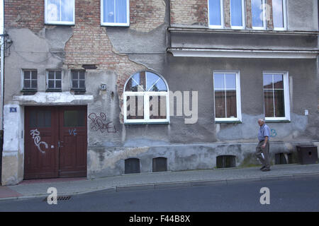 Older man walks by run down looking facades in Zielona Gora Poland Stock Photo