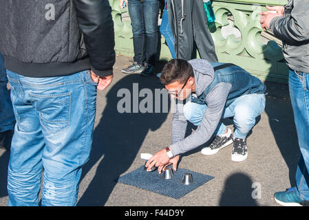 Man (thought to be Romanian) playing an illegal cup and ball, or shell game, on Westminster Bridge Stock Photo