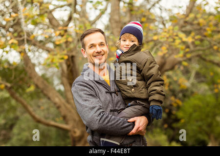 Young dad lifting his little son in park Stock Photo