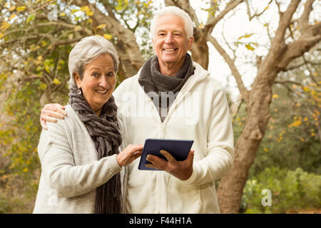 Senior couple in the park using tablet Stock Photo