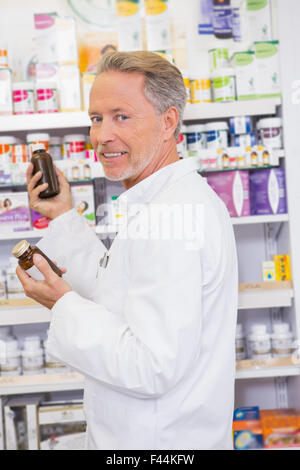 Smiling pharmacist taking jar from shelf Stock Photo - Alamy