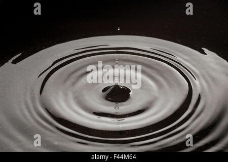 Water droplets making ripples in water Stock Photo