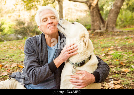 Senior man with his dog in park Stock Photo