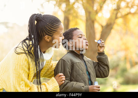 Little boy doing some bubbles with his mother Stock Photo