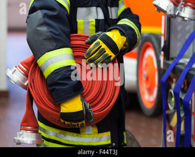 Fireman in action with water hose Stock Photo