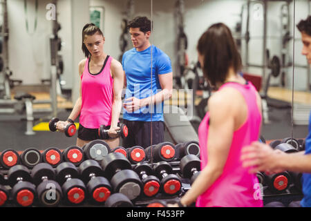 Fit couple working out in weights room Stock Photo