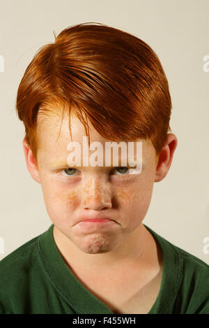 Modeling a frown, a self confident red-headed five year old boy poses in a studio in Laguna Niguel, CA. Stock Photo