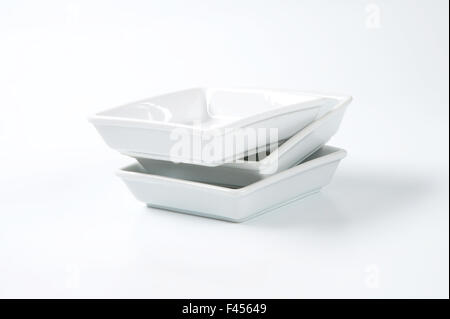 a stack of square white plates isolated on white background with ...