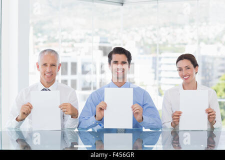 Smiling business team showing paper Stock Photo