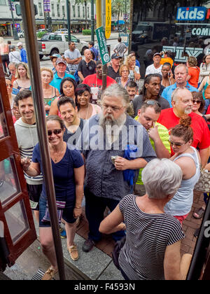 An eclectic multiracial crowd enters a trolley on Canal Street in New Orleans. Stock Photo