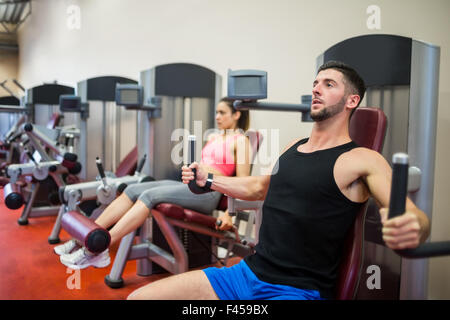 Focused man working out on the weights machine Stock Photo
