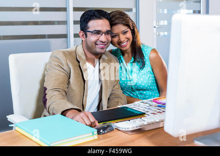 Happy partners working together on computer Stock Photo