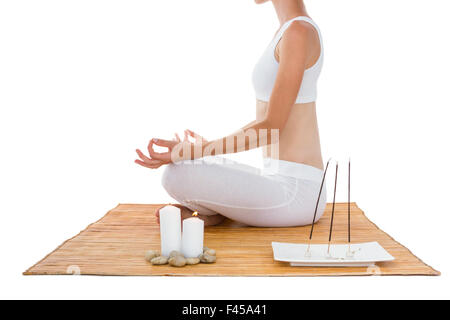 Fit woman meditating on bamboo mat Stock Photo