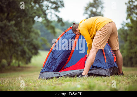 Handsome hipster pitching his tent Stock Photo