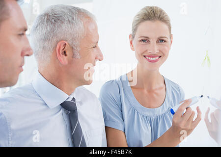 Businesswoman drawing graph on the board Stock Photo