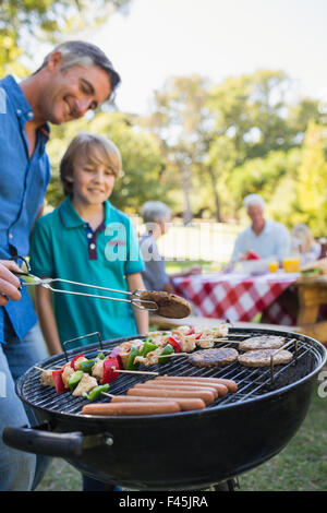 Happy father doing barbecue with his son Stock Photo