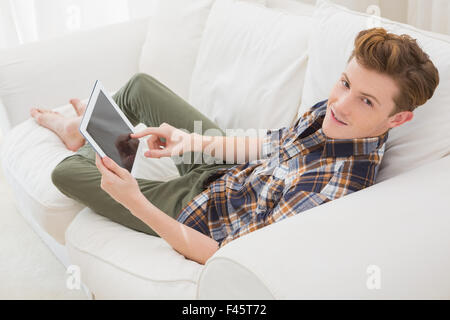 Handsome man using tablet computer on sofa Stock Photo