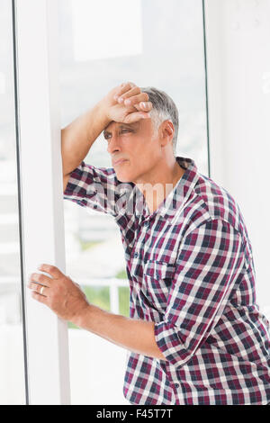 Thoughtful businessman looking through the window Stock Photo