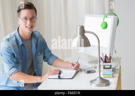 Happy handsome man writing on notebook Stock Photo