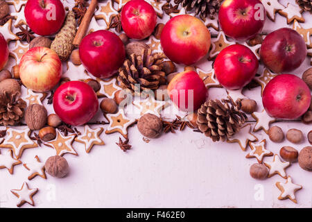 Christmas background. Gingerbread cookies, apples, spices and nuts. Image toned in vintage style. Selective focus. Stock Photo