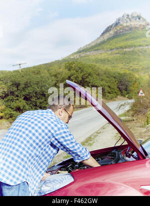 Adult man is standing near his broken car Stock Photo