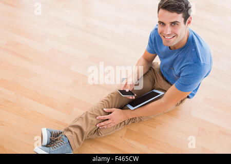 Businessman sitting on the floor using tablet Stock Photo
