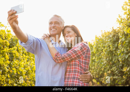 Happy couple embracing and taking selfies Stock Photo