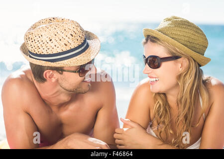 Happy couple relaxing together in the sand Stock Photo