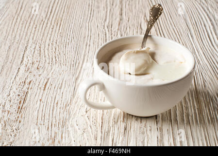 Hand-made cream yogurt in a bowl with spoon. Stock Photo