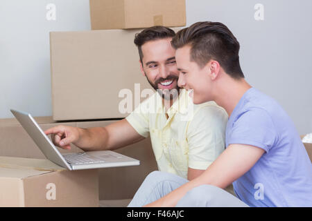 Happy homosexual couple looking at laptop computer Stock Photo