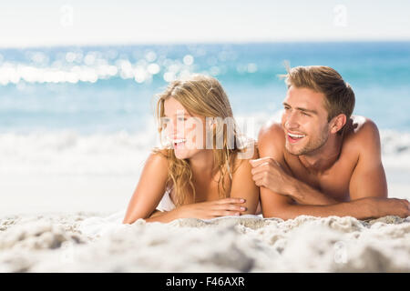 Happy couple relaxing together in the sand Stock Photo