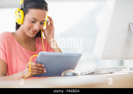 Creative businesswoman listening music with her tablet Stock Photo