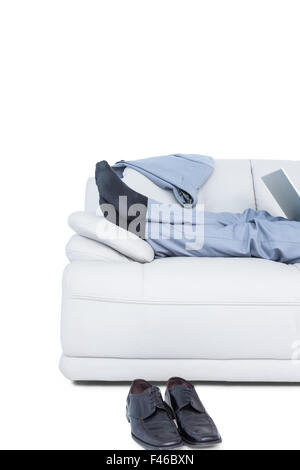 Businessman lying on couch legs only visible Stock Photo