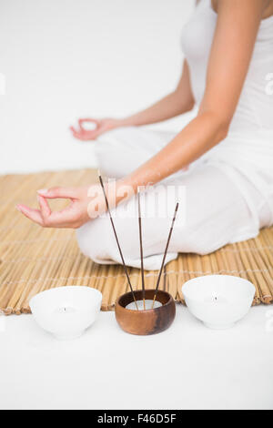 Fit woman meditating on bamboo mat Stock Photo