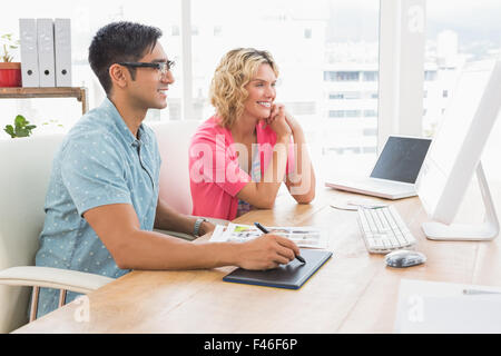 Smiling colleagues using digitizer and computer Stock Photo