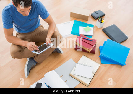 Young businessman working on the floor with tablet Stock Photo