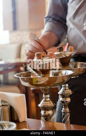 Preparing the shisha, aka nargile or hookah at a restaurant by placing the charcoals on top. A very middle eastern custom. Stock Photo