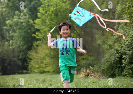 Boy playing kite in field Stock Photo