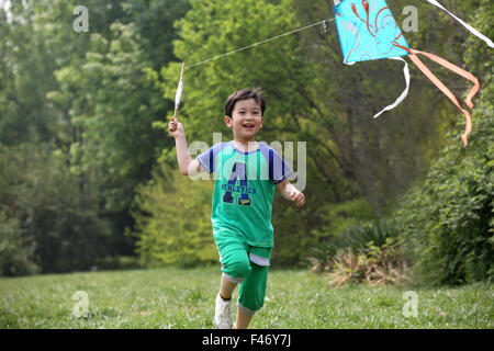 Boy playing kite in field Stock Photo