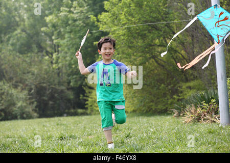 Boy playing kite in field Stock Photo